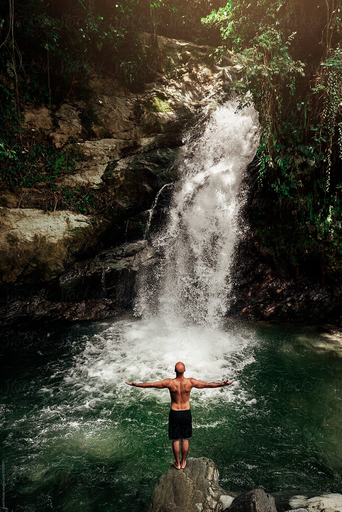 Young man meditating and relax doing yoga near of waterfall.