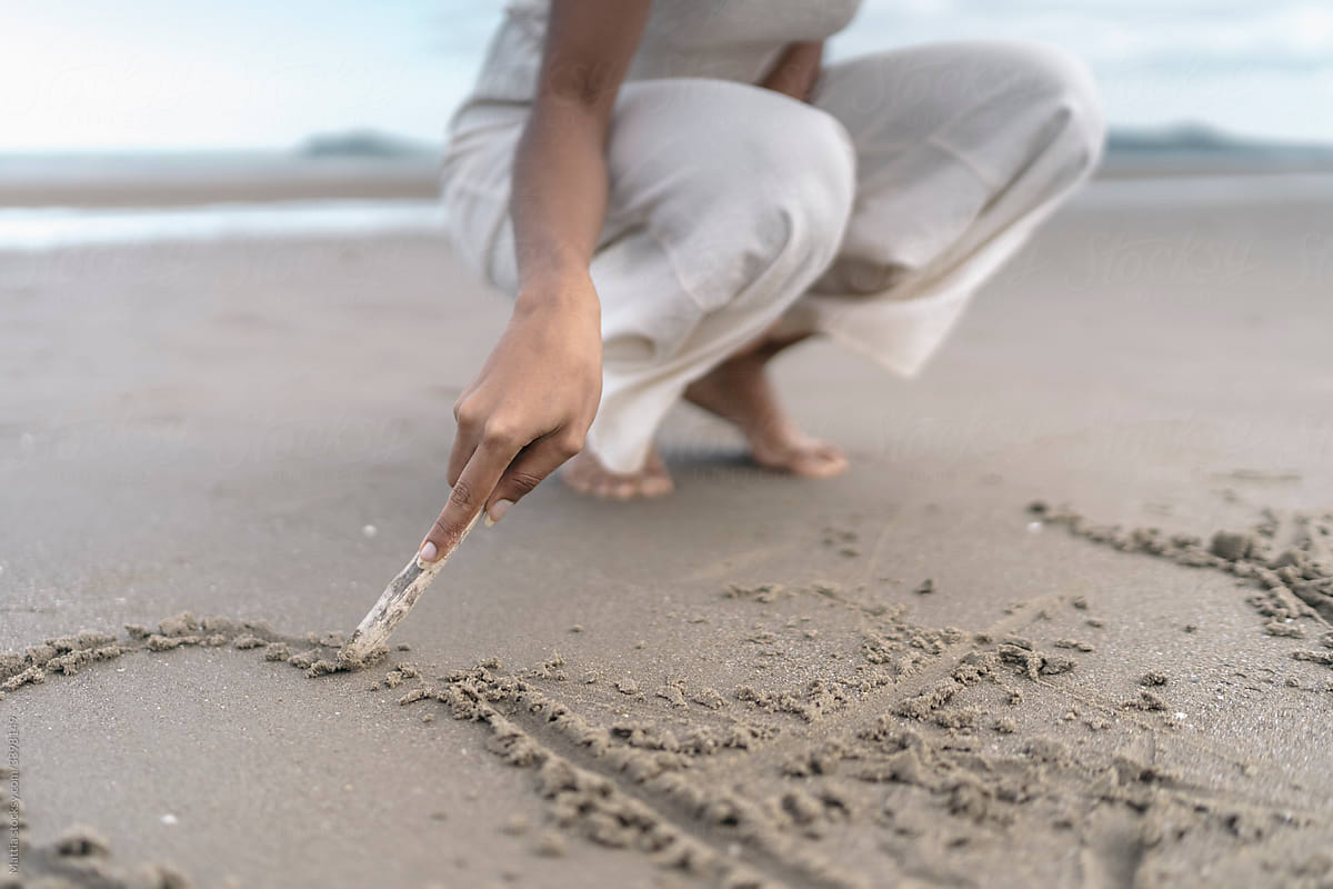 Anonymous Woman Drawing on the Sand