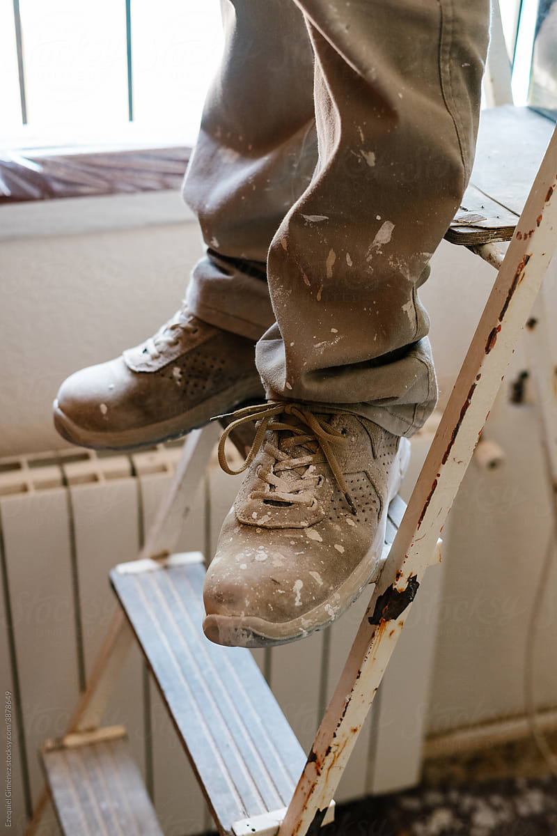 Unrecognized mason\'s feet on a ladder