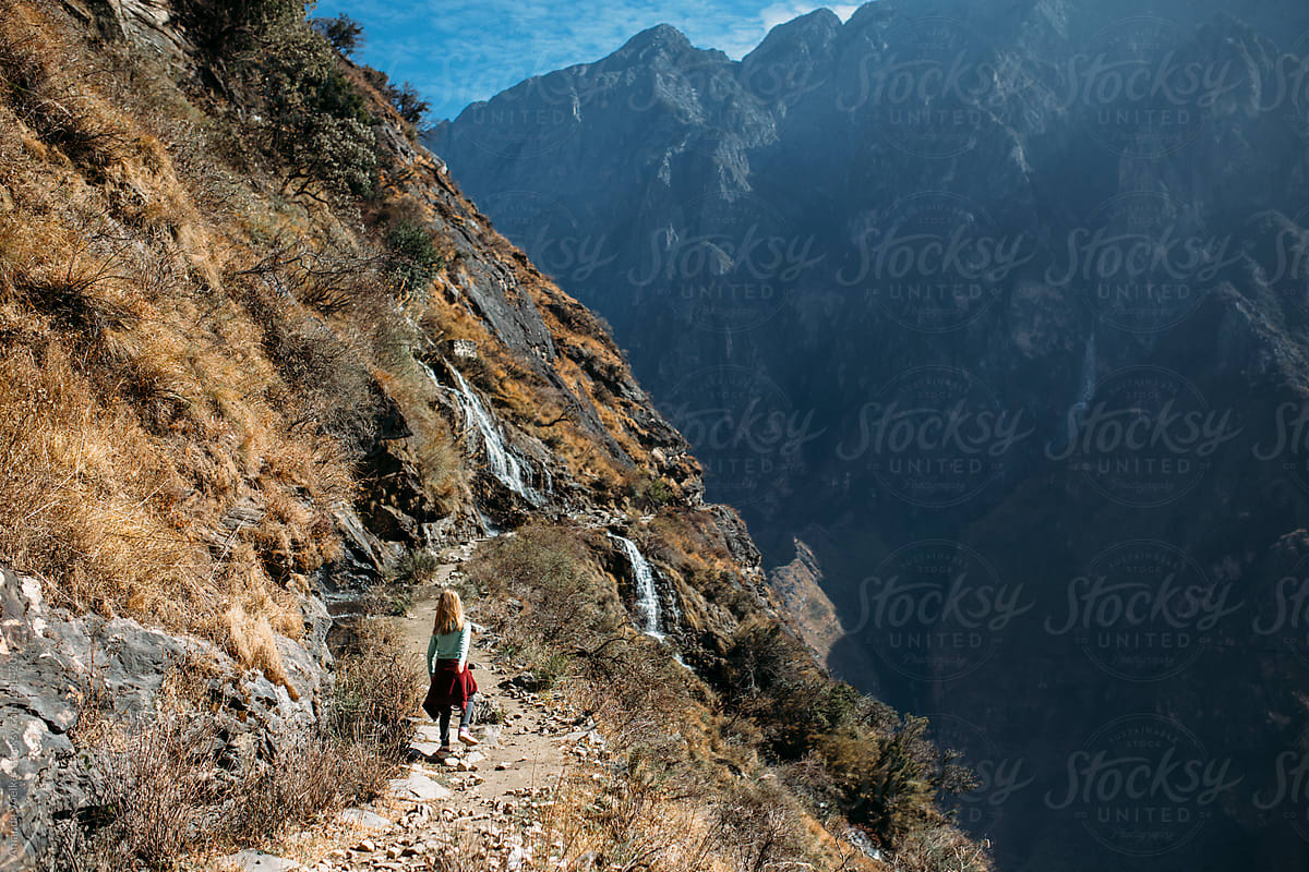 Back view of Young Girl Hiking on a high mountain pass