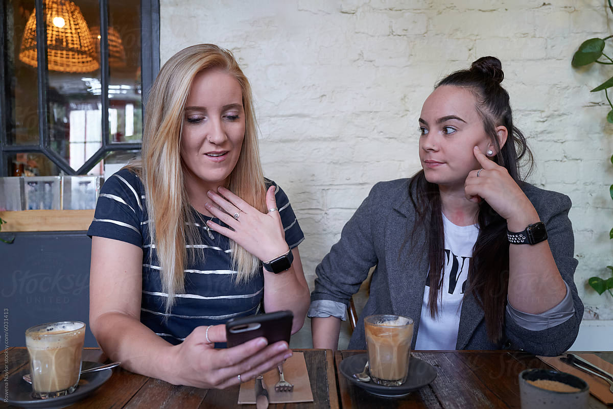 Lesbian couple share fun social media posts whilst at a cafe