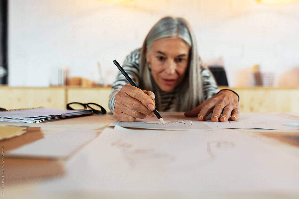 Senior woman drawing on table in office