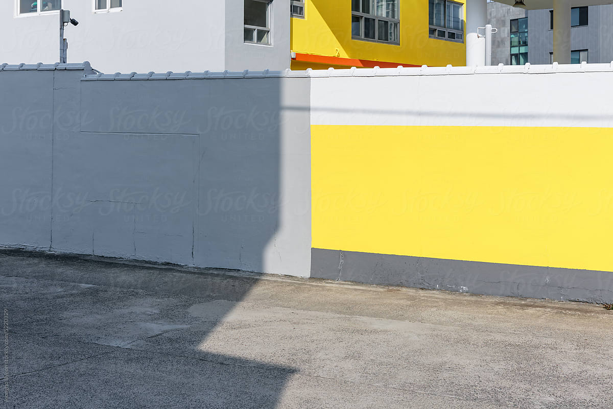 Yellow painted concrete walls and shadows of buildings.