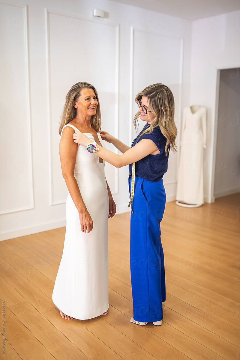 Mature Woman Trying On Wedding Dress In A Store" by Stocksy Contributor  "Lupe Rodriguez" - Stocksy