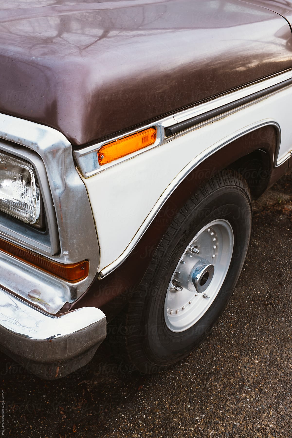 Detail of brown vintage truck, focus on headlight and front wheel