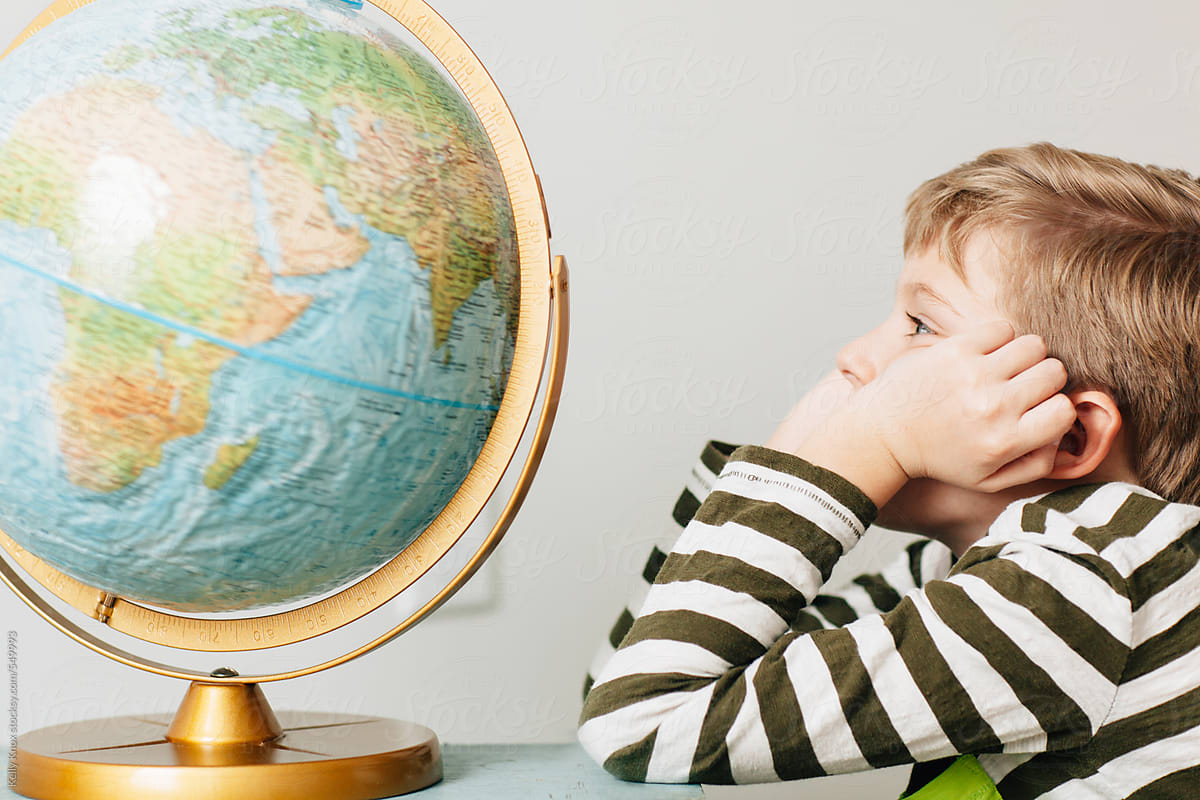 thinking child looks up at a globe
