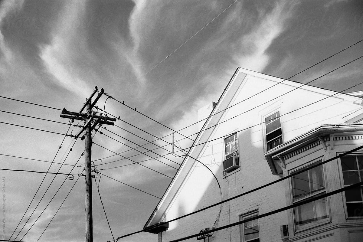 House, wires, and wispy clouds