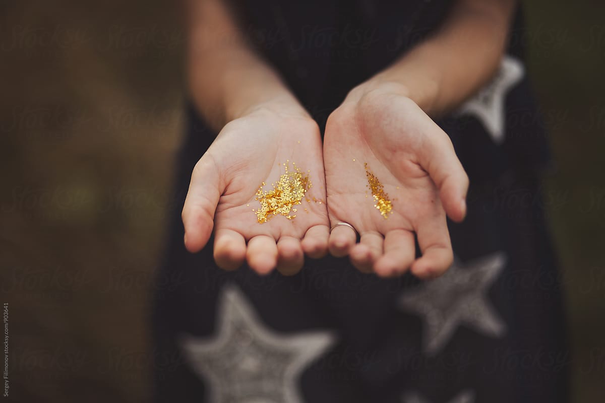 Hands of young female with golden spangles