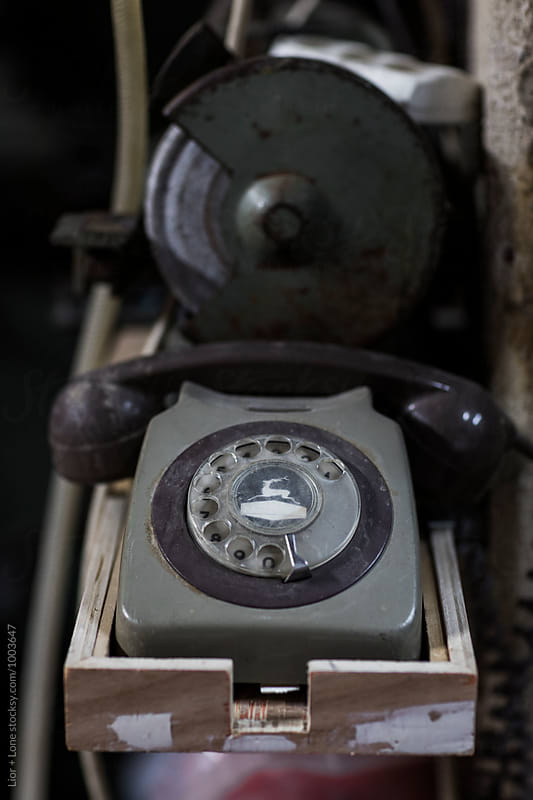 Old dial phone on a wooden shelf