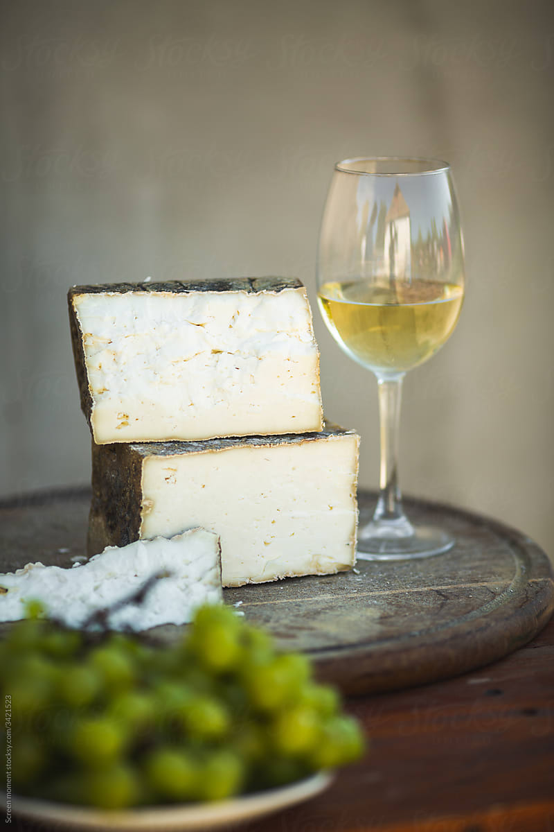 Goat cheese and glass of wine on rustic background