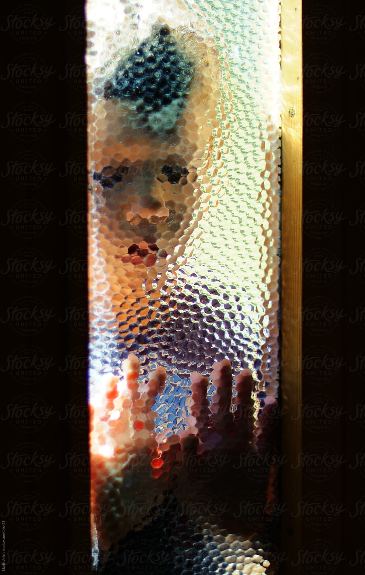 Boy behind frosted glass