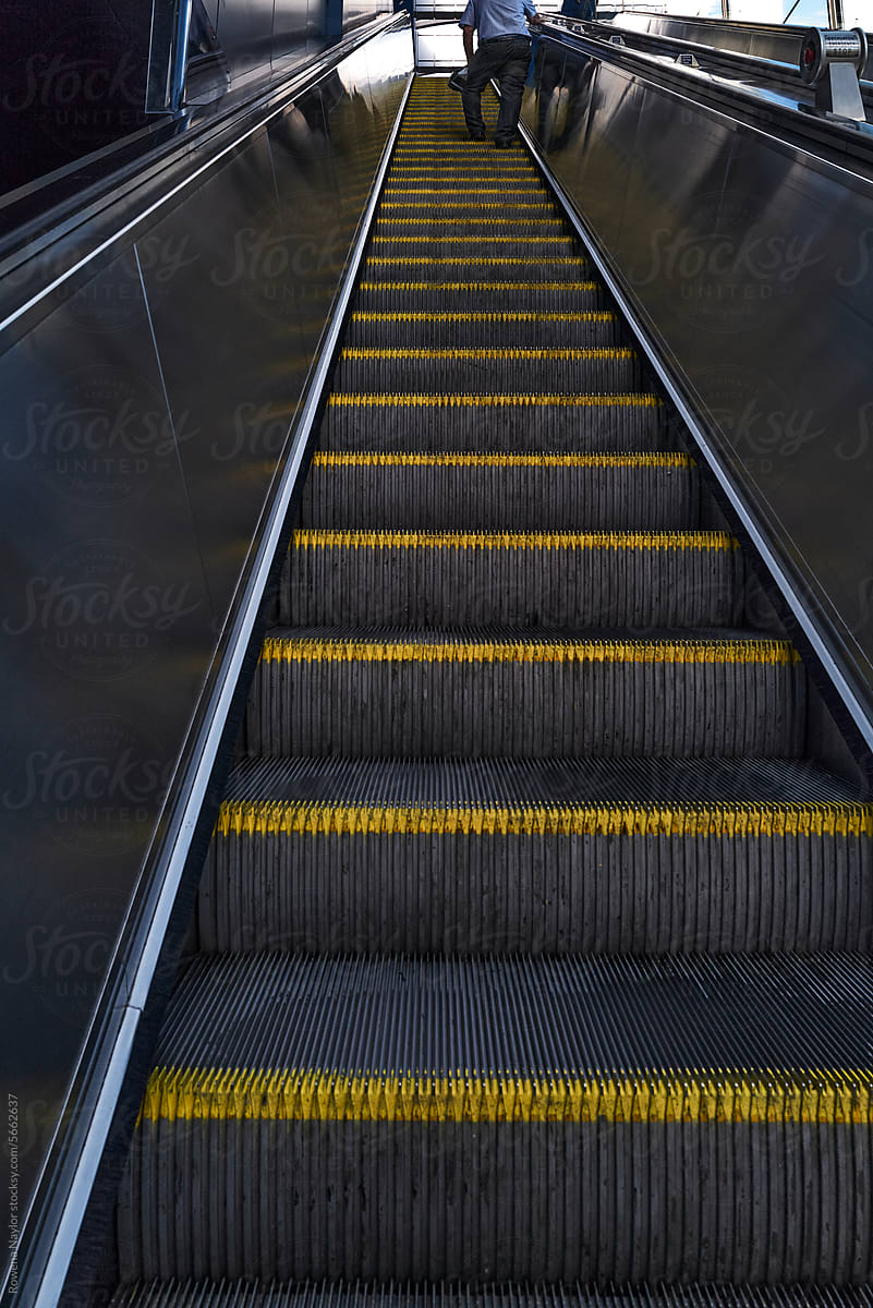 Commuter using escalator