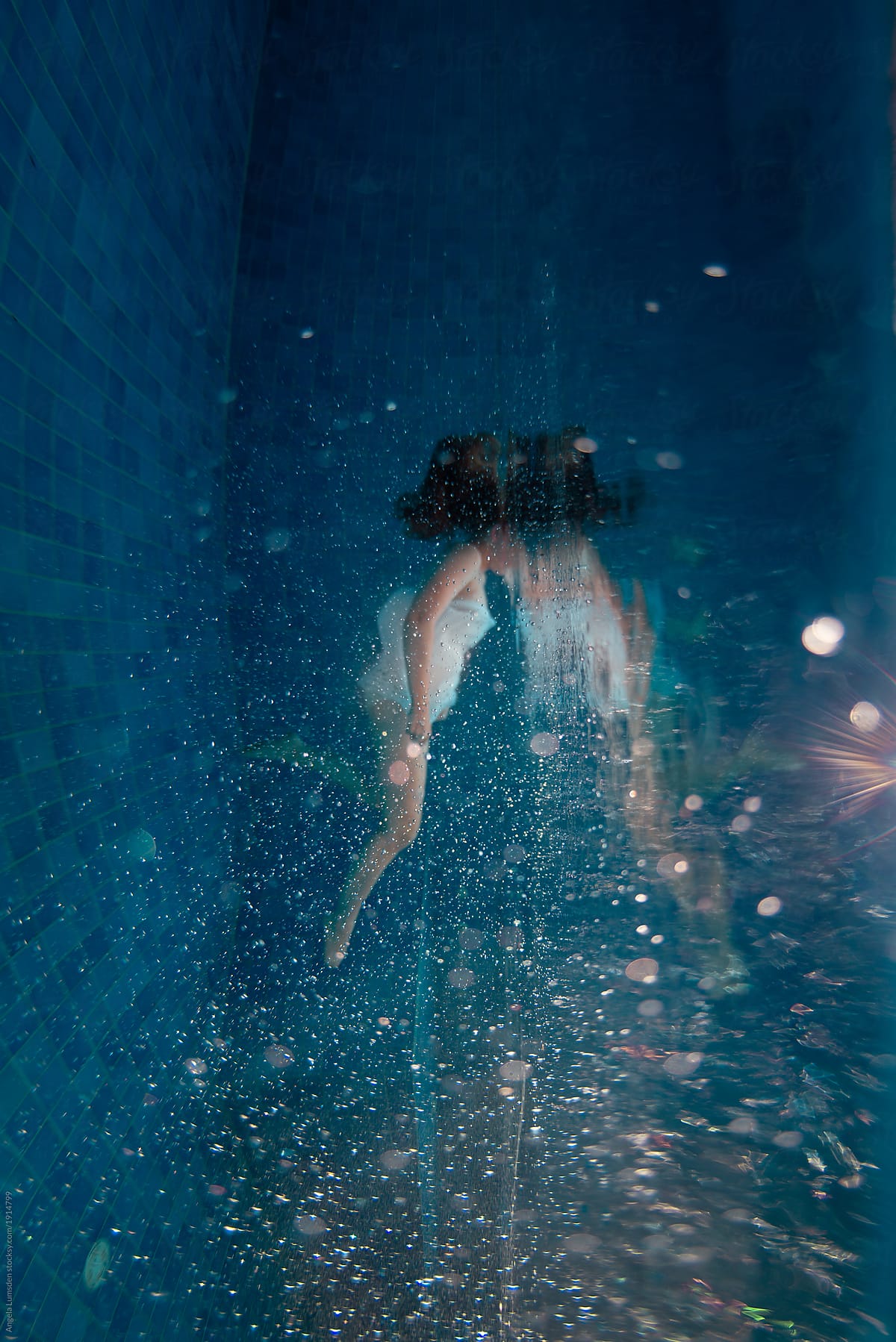 Girl underwater in a blue pool