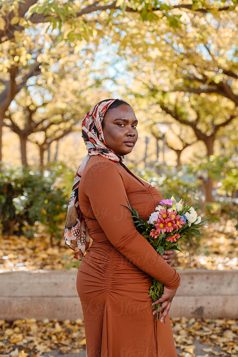 Black muslim woman holding flowers