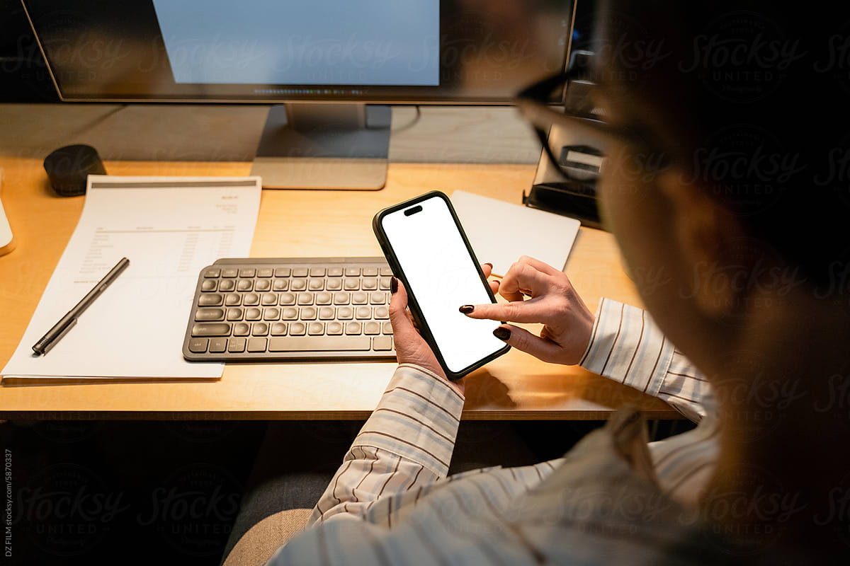 A woman uses a mobile phone with white screen