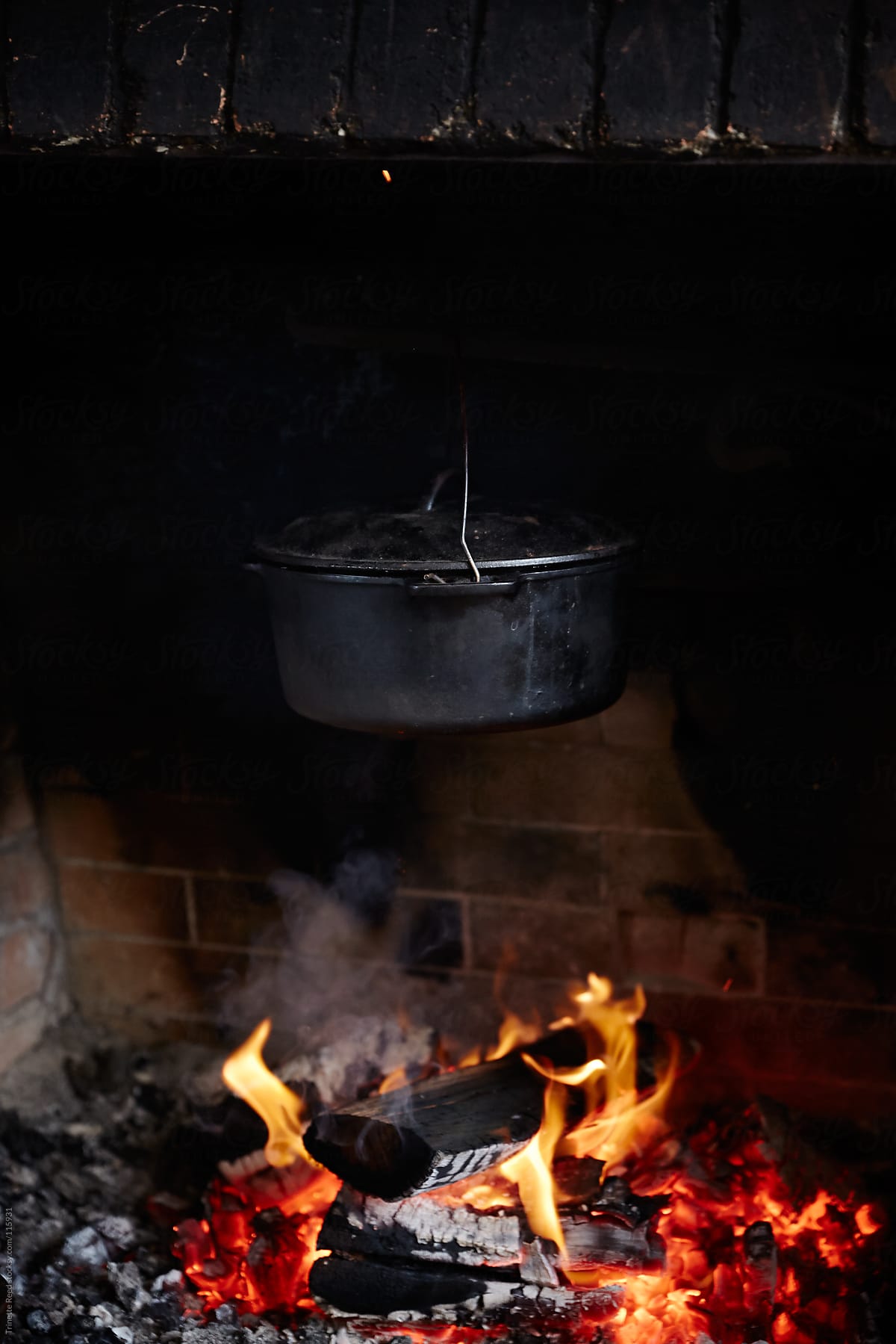 Cast iron pot cooking over an fire heart inside a cabin