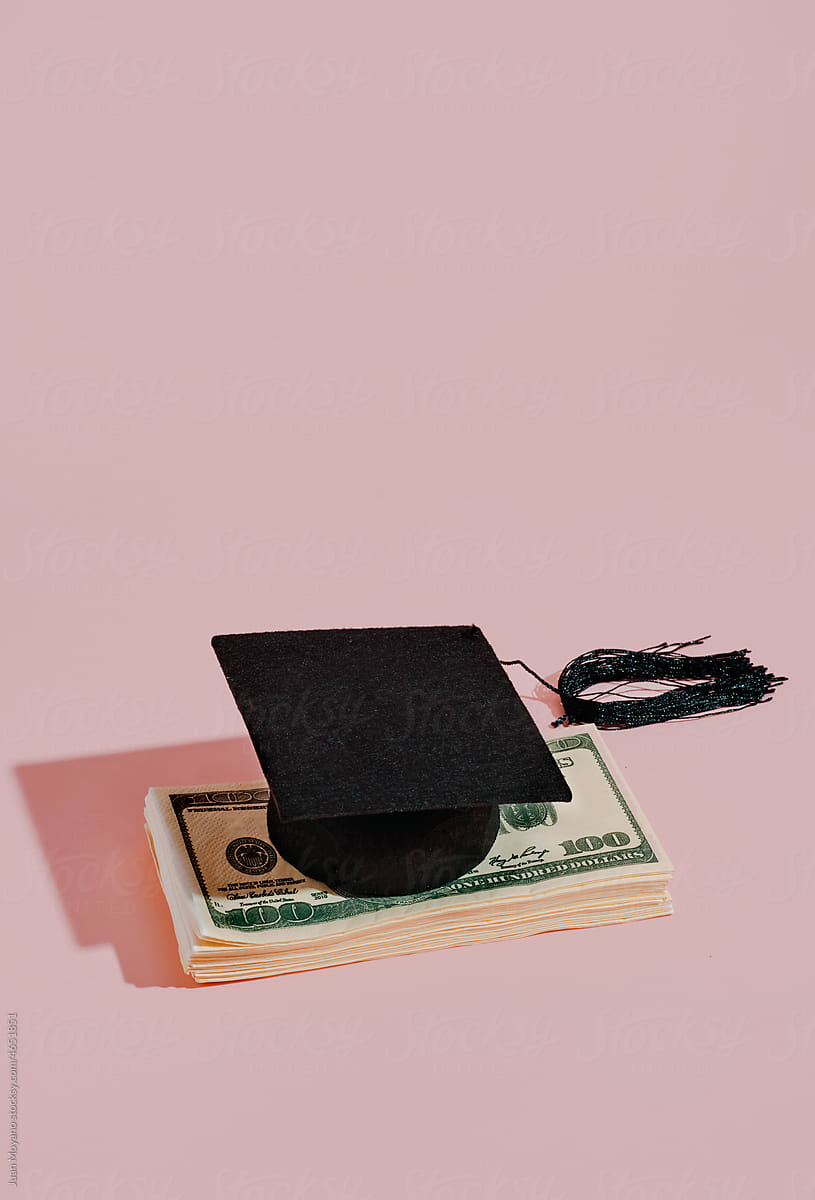 graduate cap on top of a pile of banknotes