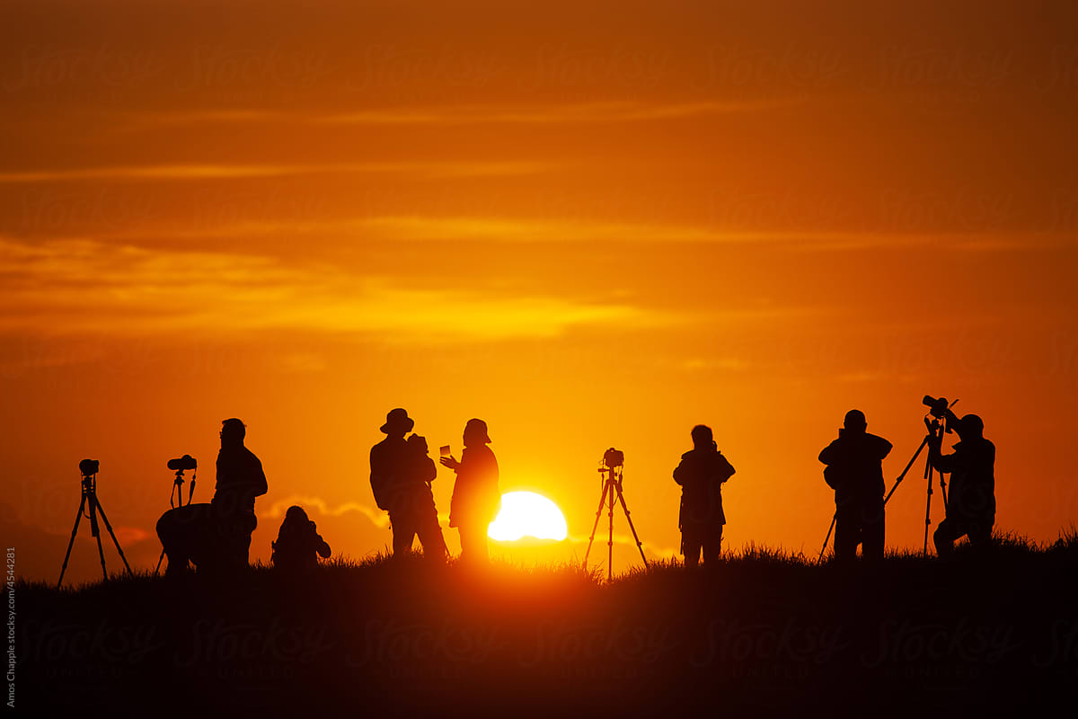 A group of photographers capture sunrise.