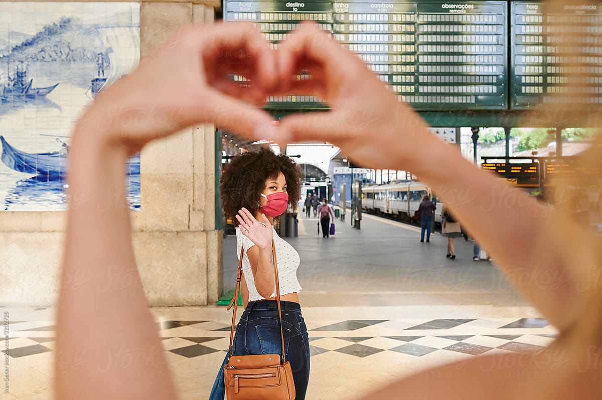 Woman greeting a friend with a heart symbol