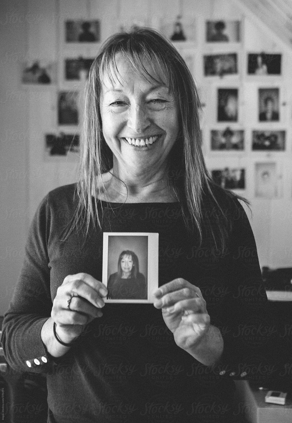 Black and white Portrait of a woman holding an instant photo of herself