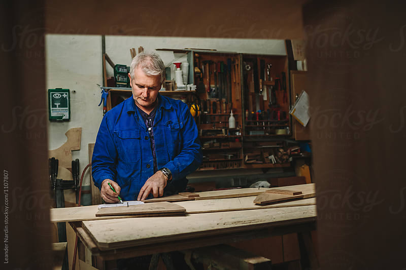 old carpenter in his wood workshop