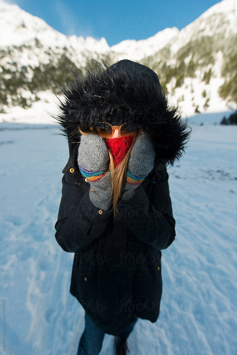 Woman freezing on the snow covered with winter clothes