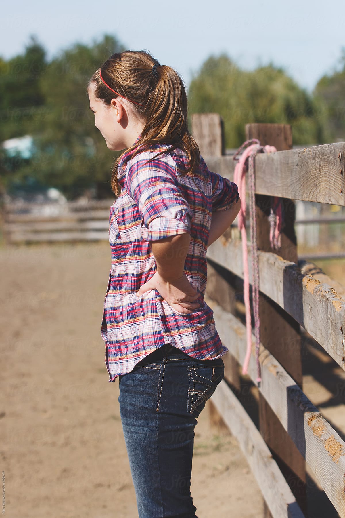 Country Girl Stands Along The Fence Inside An Arena By Tana Teel