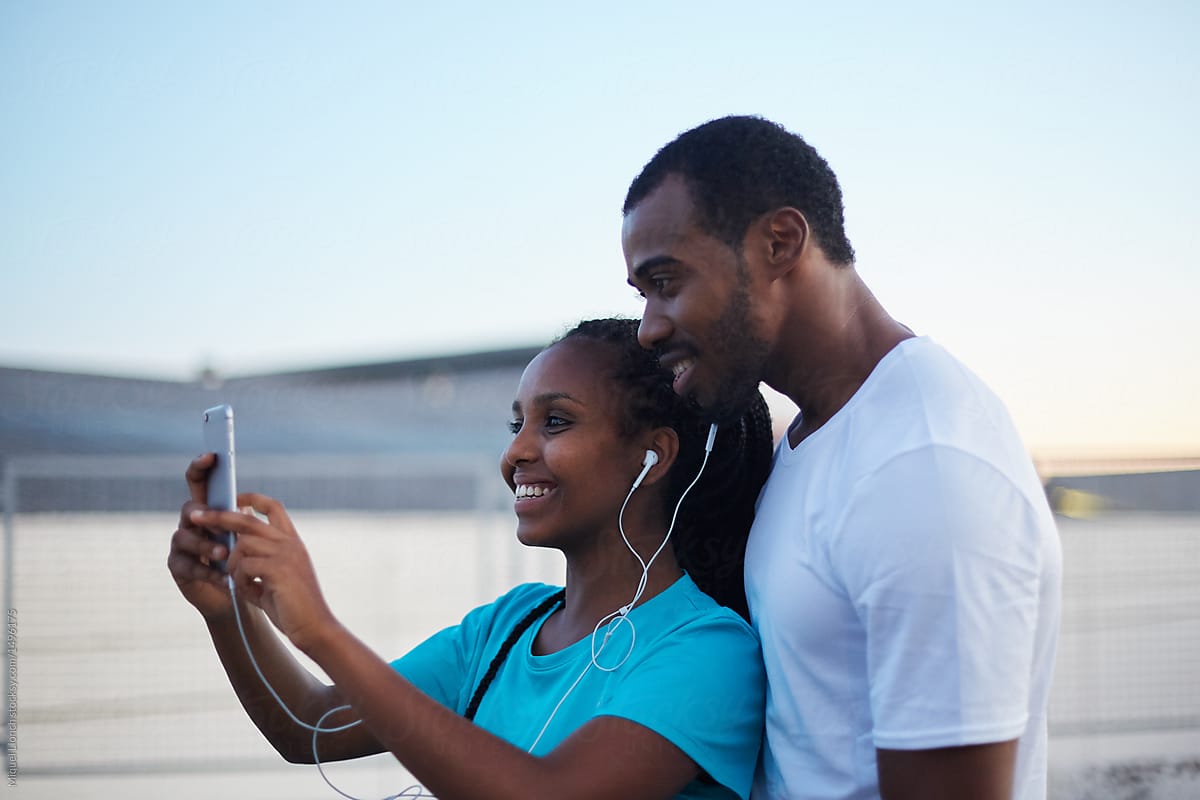 Young black couple taking a self-portrait in urban area