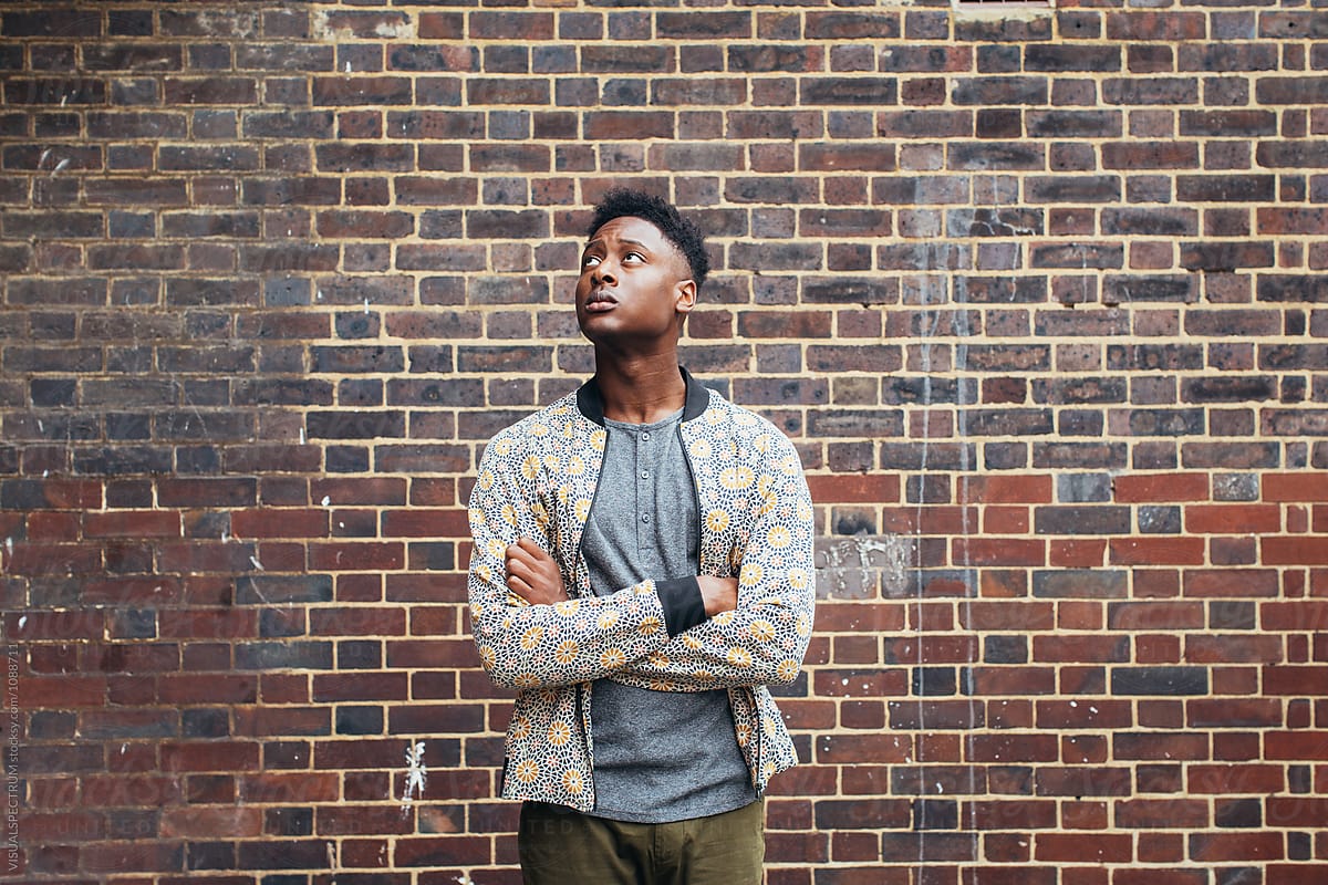 Good-Looking Young Black Man Standing in Street and Looking Up