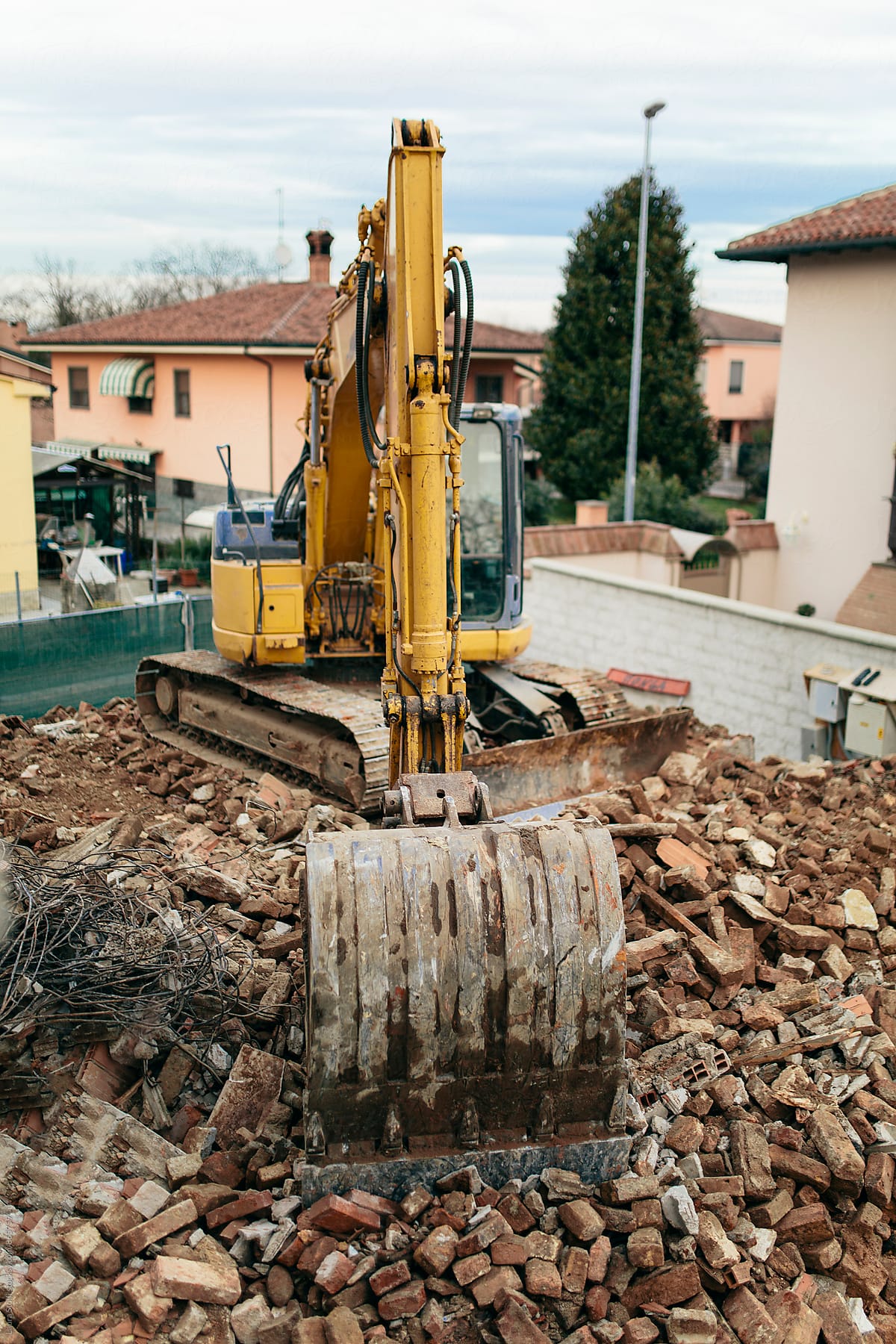 Above sight of bulldozer parked on top of ancient building ruins in Italy