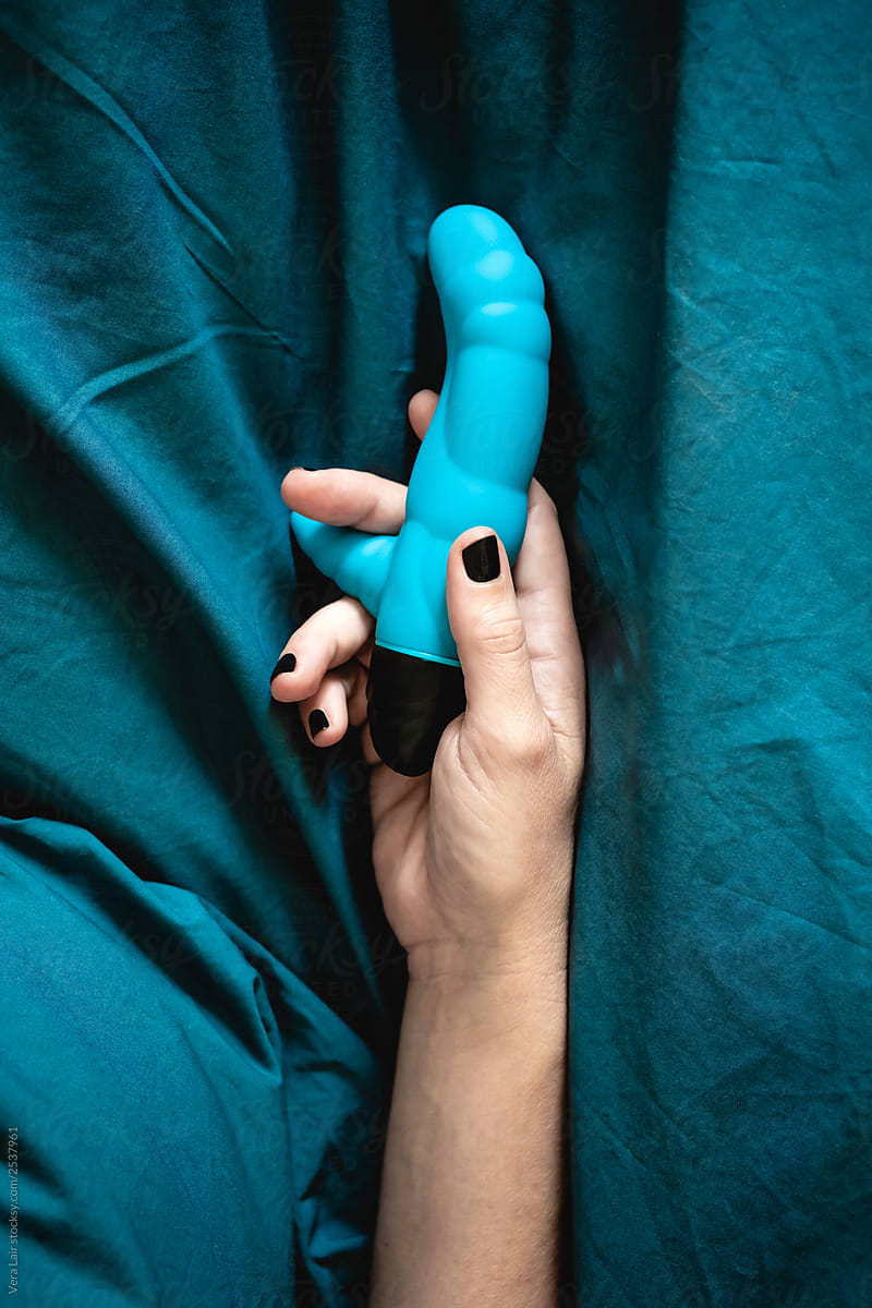 Woman\'s hand holding a blue sex toy