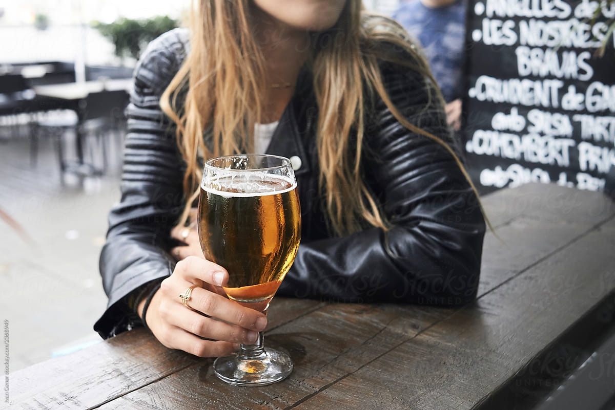 Anonymus female having beer in bar terrace.