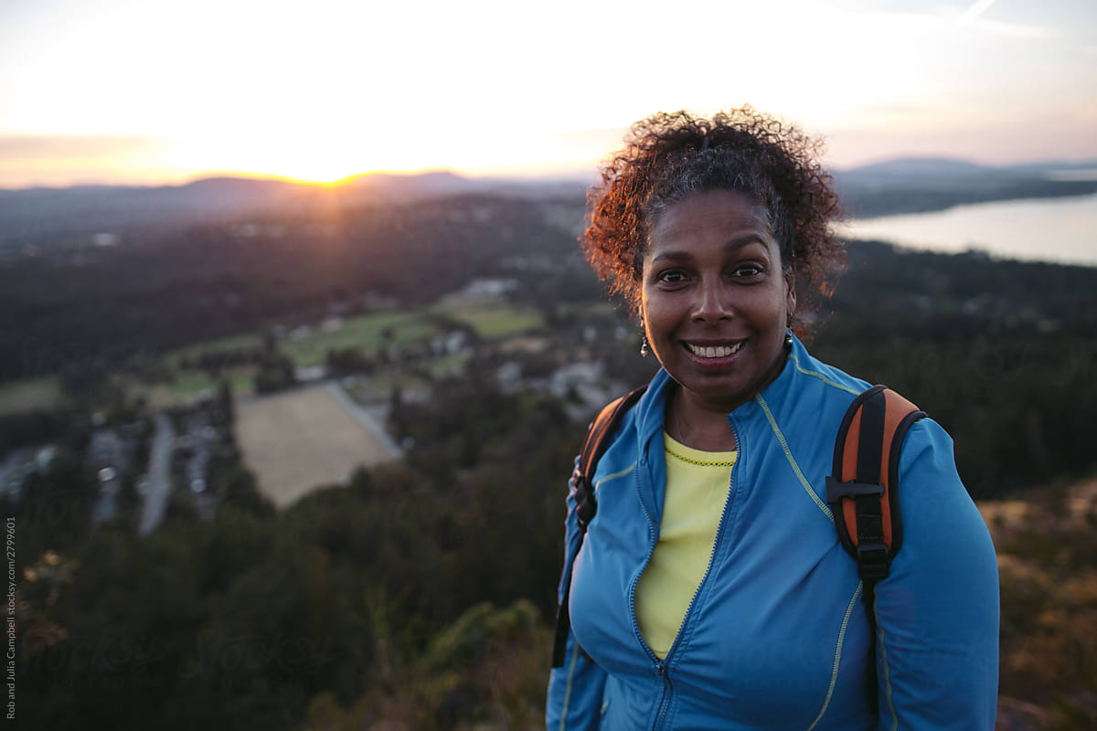 Portrait of middle age woman on mountain at sunset.