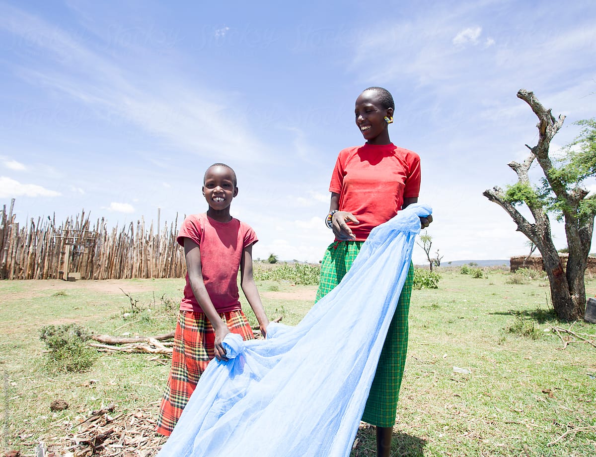 Mother and Daughter preparing mosquito net for daughter\'s sleeping area.