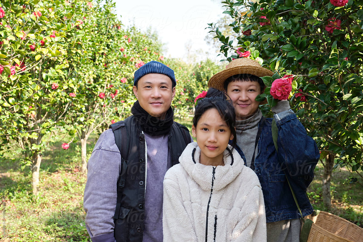 Asian family of three in the camellia grove