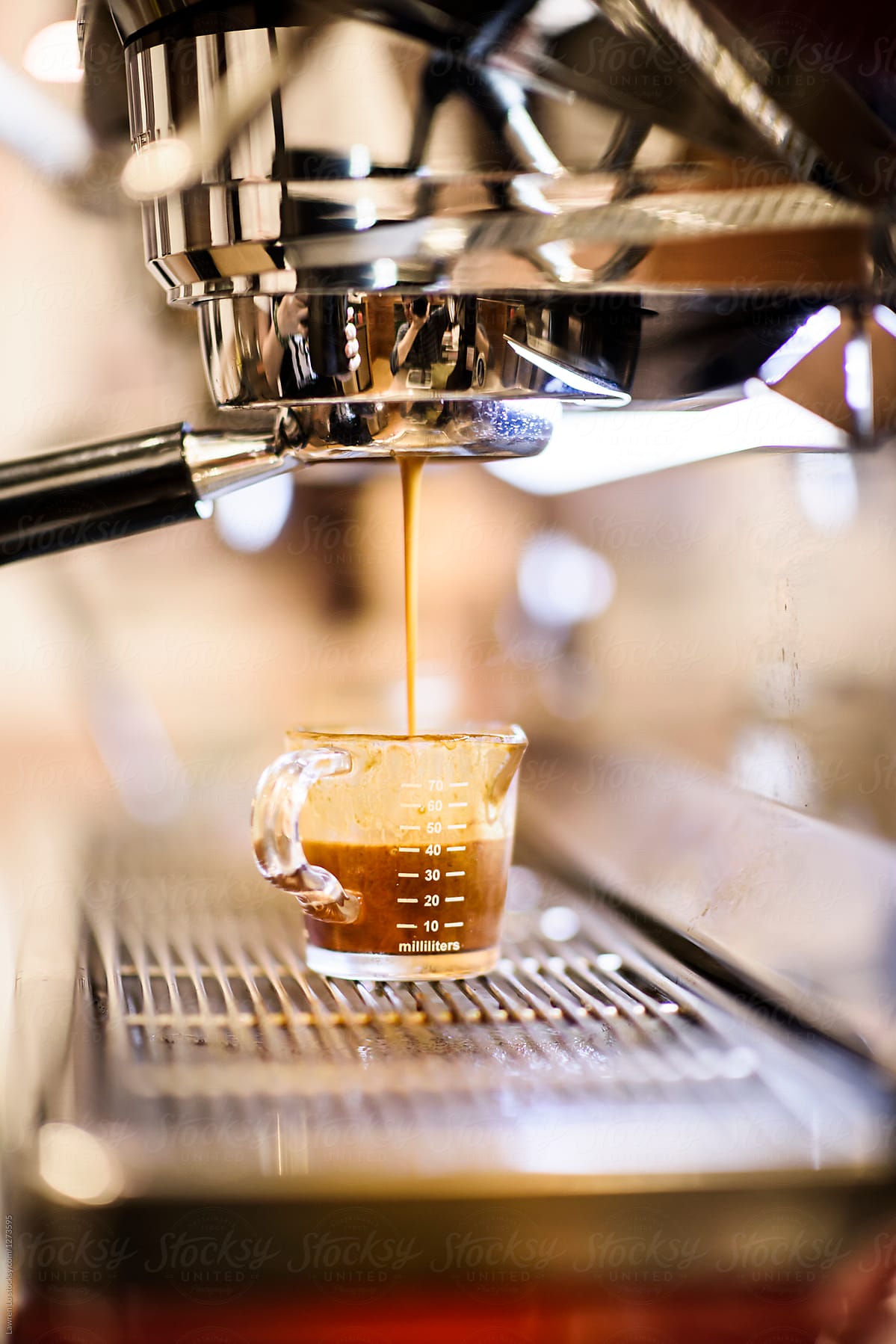 Espresso coffee preparation pouring in glass pitcher
