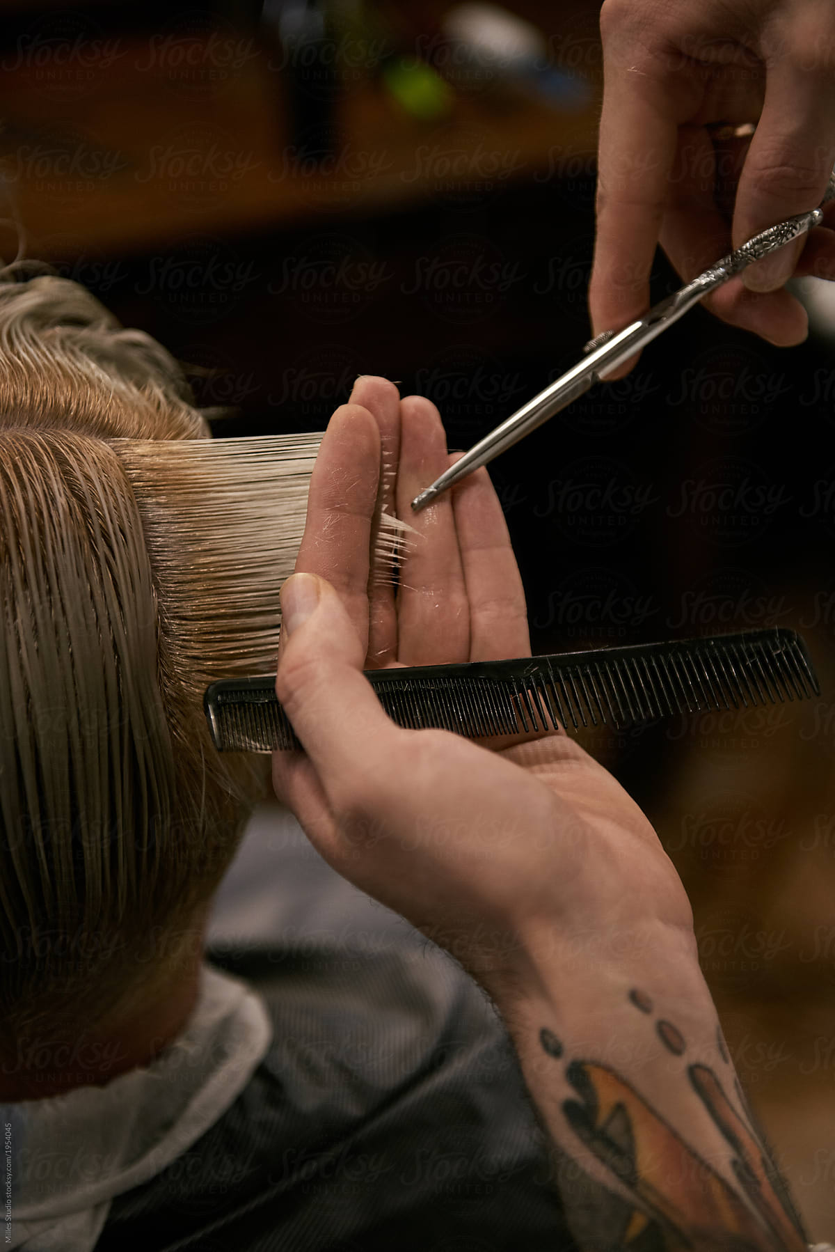 Close-up of man cutting hair of customer