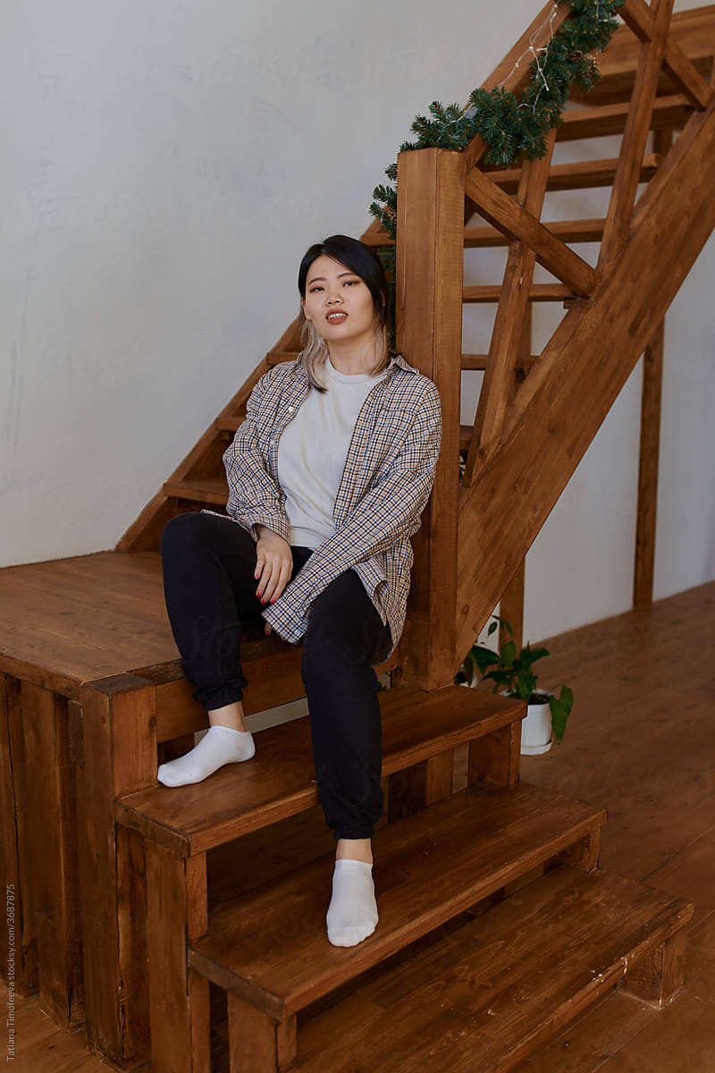 asian woman on wood stair at home