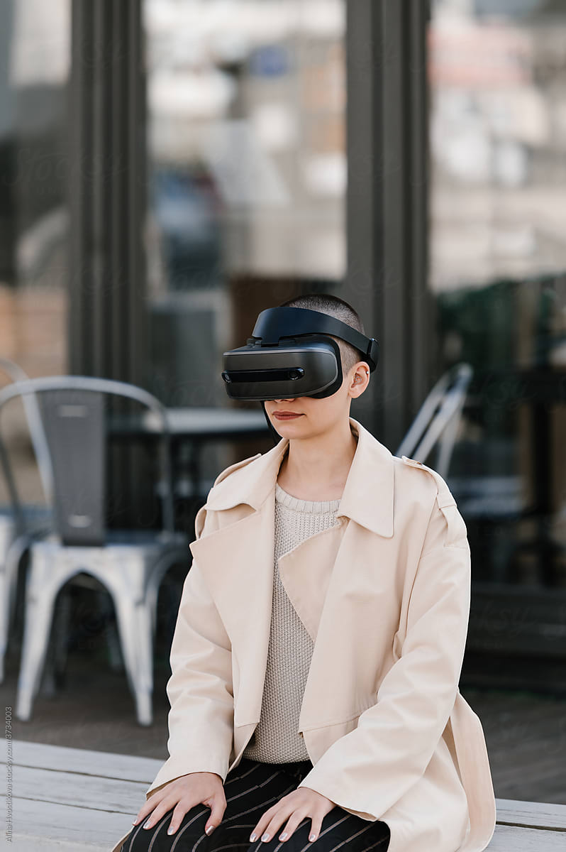 Young woman in VR headset sitting on bench