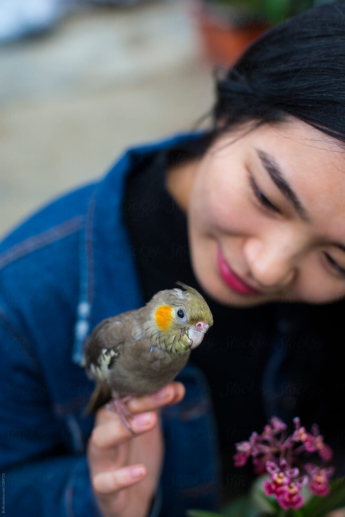 Young Asian Woman with her Parrot in the Garden