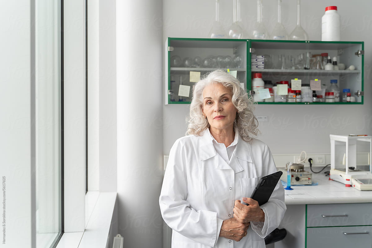 Senior Female Scientist Portrait Holding Tablet In Lab