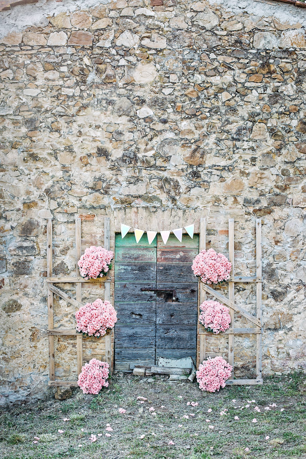 Party decoration with flowers next to a grunge wooden door of a stone farm house