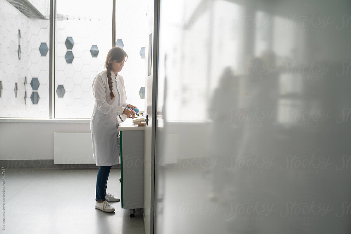 Scientist Disinfecting Her Workplace In Laboratory