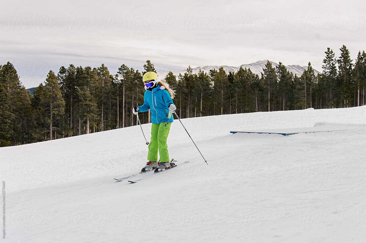 Pre-teenage girl skiing in a small terrain park in winter