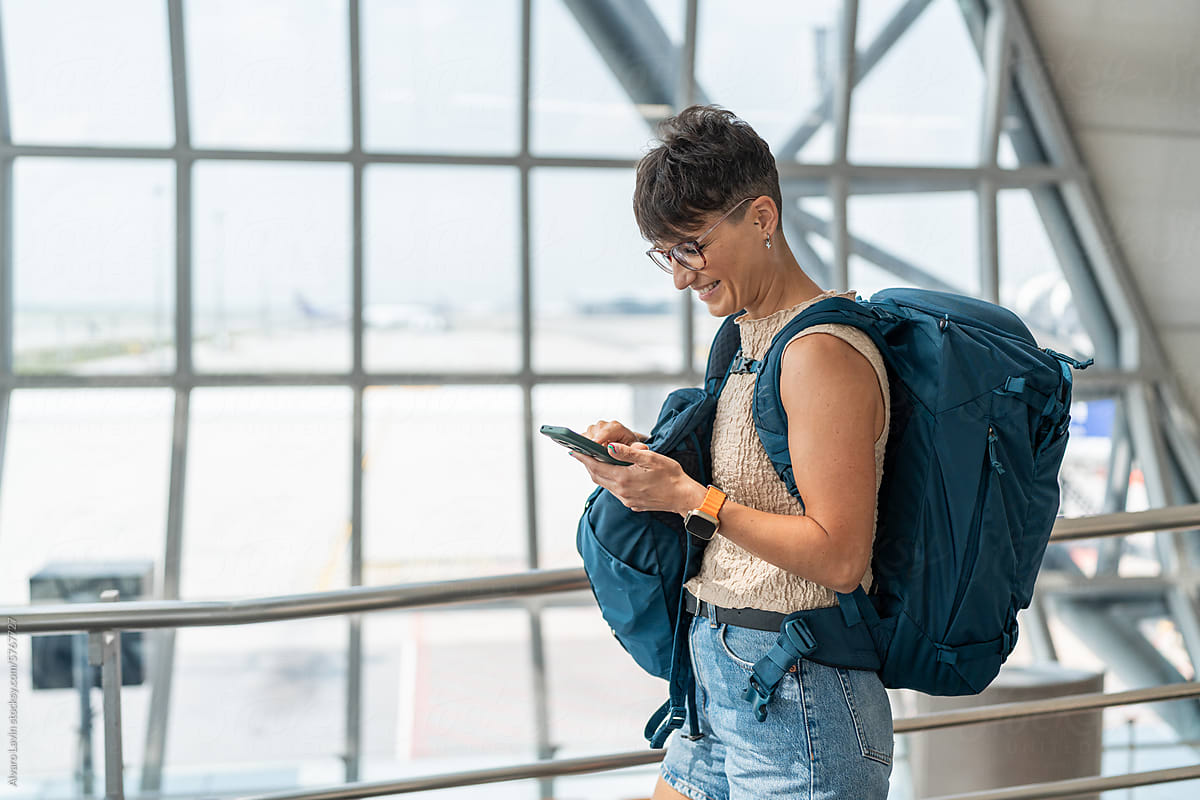 Traveler using mobile phone at airport.