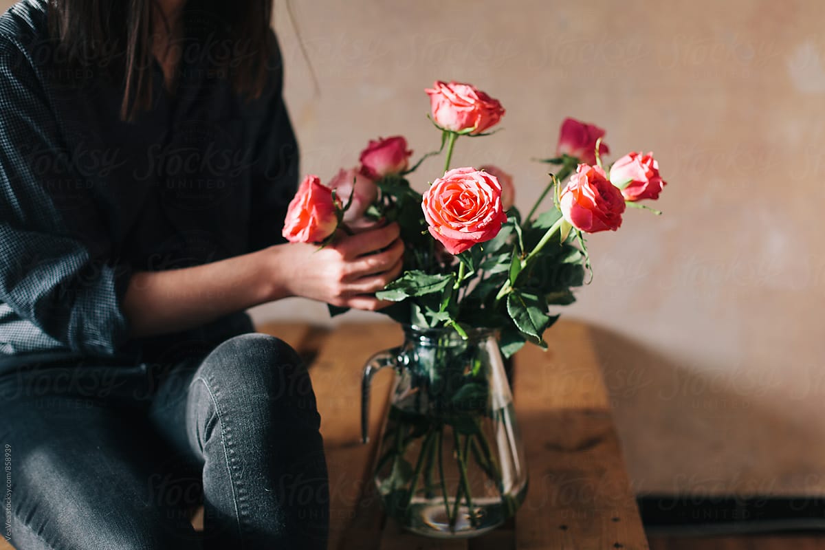 Woman arranging a bouquet of roses indoor