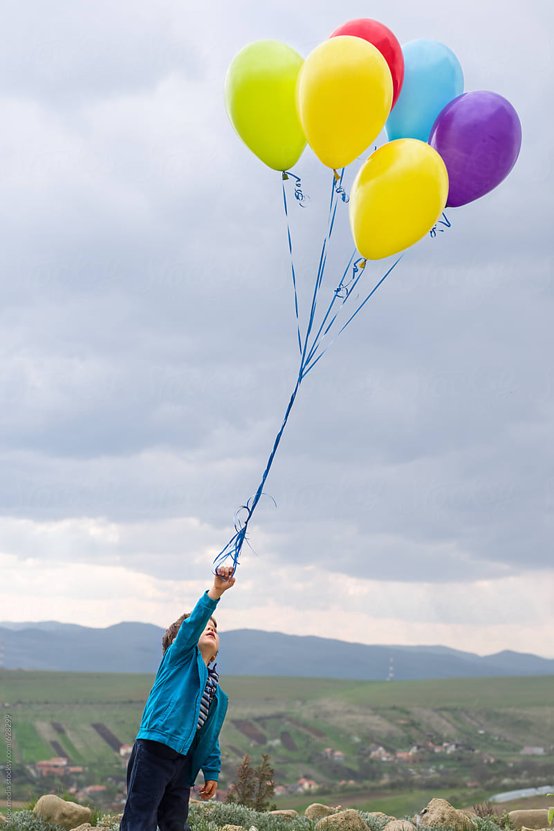 Young boy trying to fly with balloons