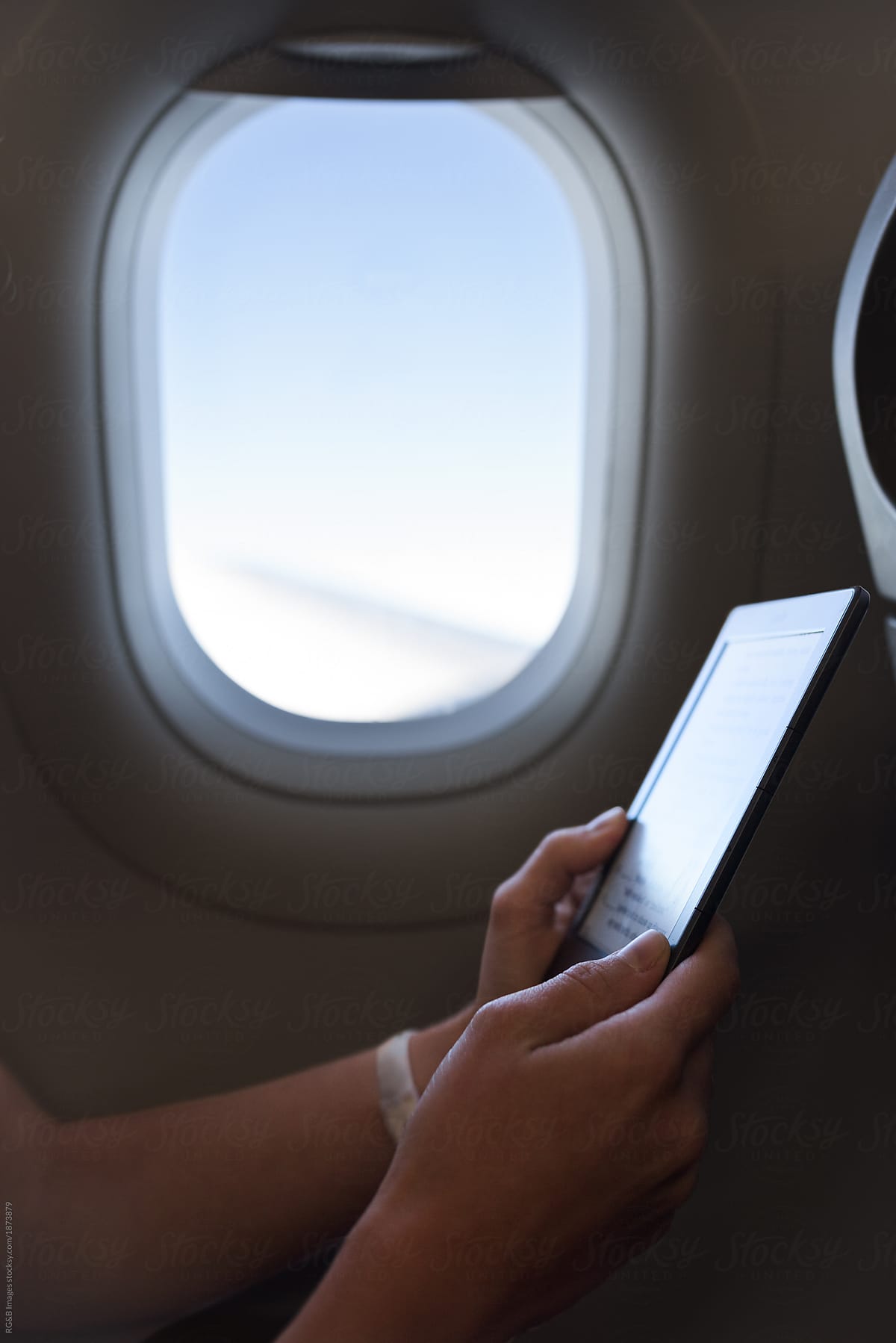 Woman spending her time in airplane with an e-reader