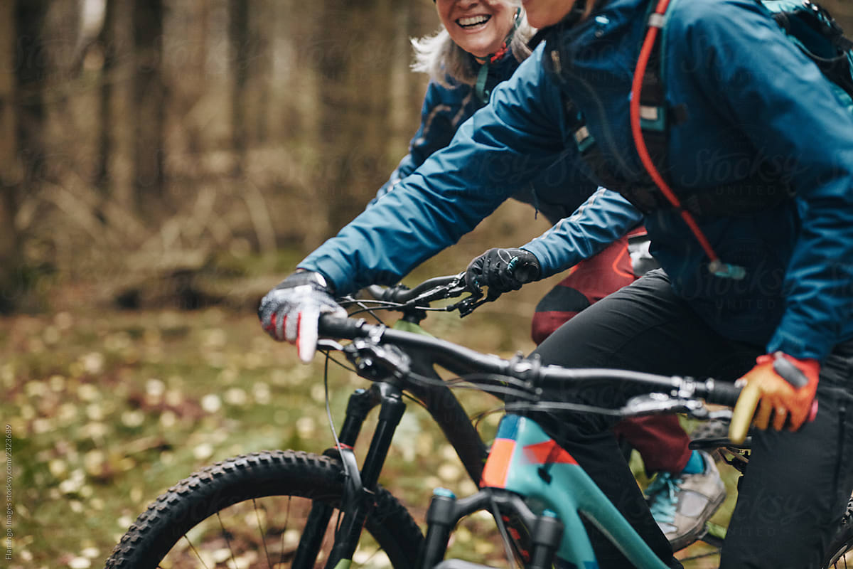 Two mountain bikers riding together on a forest trail