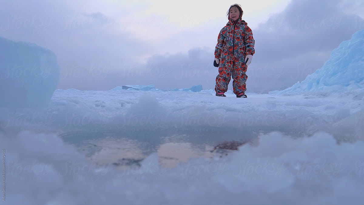 Young indigenous Inuit, Inuk, Eskimo at sea-ice hole - learning danger